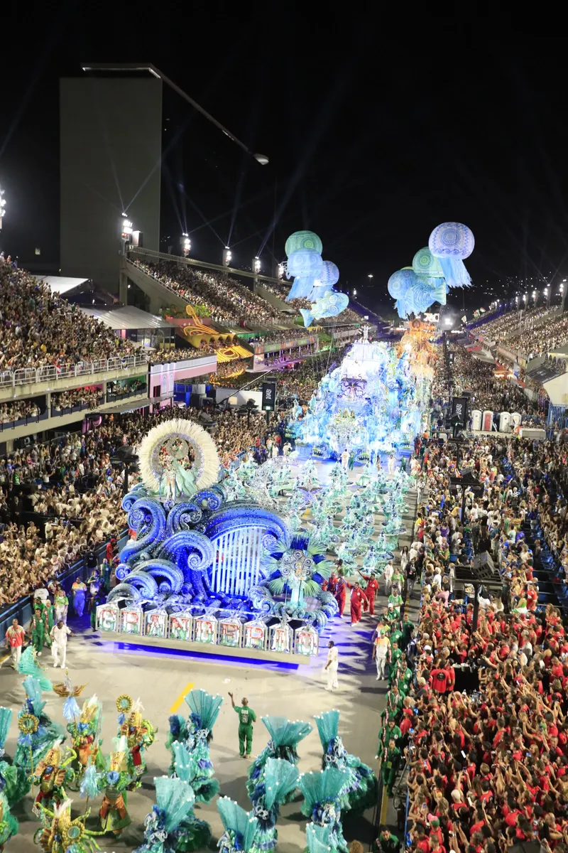 Aerial view of a samba school parading down the packed Sambadrome avenue